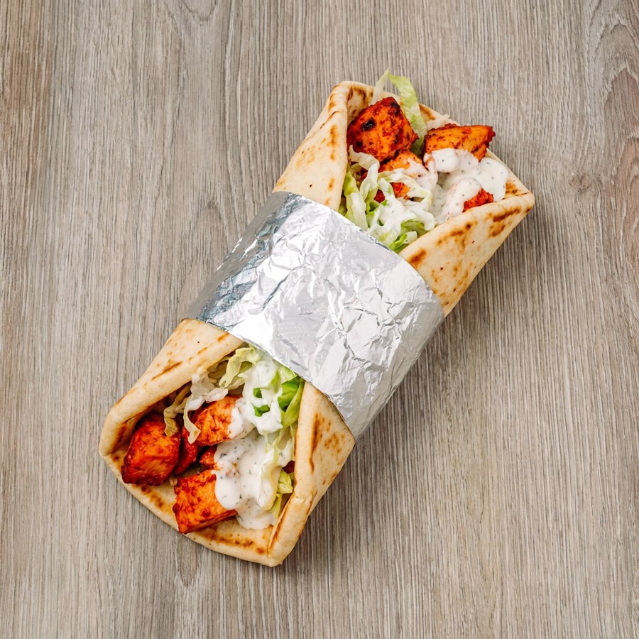 Chicken gyro wrapped in warm pita with lettuce and white sauce